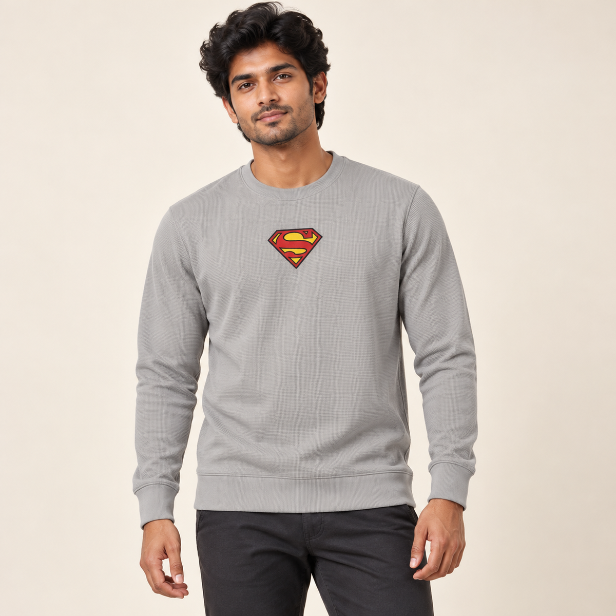 Light grey textured long sleeve crew neck sweatshirt with the original red and yellow shield graphic on an adult male model.