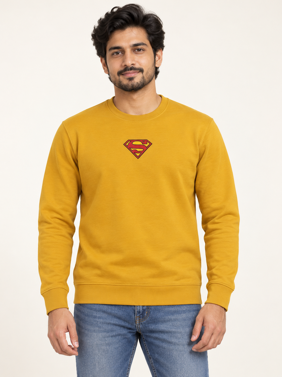 Mustard long sleeve crew neck sweatshirt with a small red and yellow shield chest graphic, on an adult model.