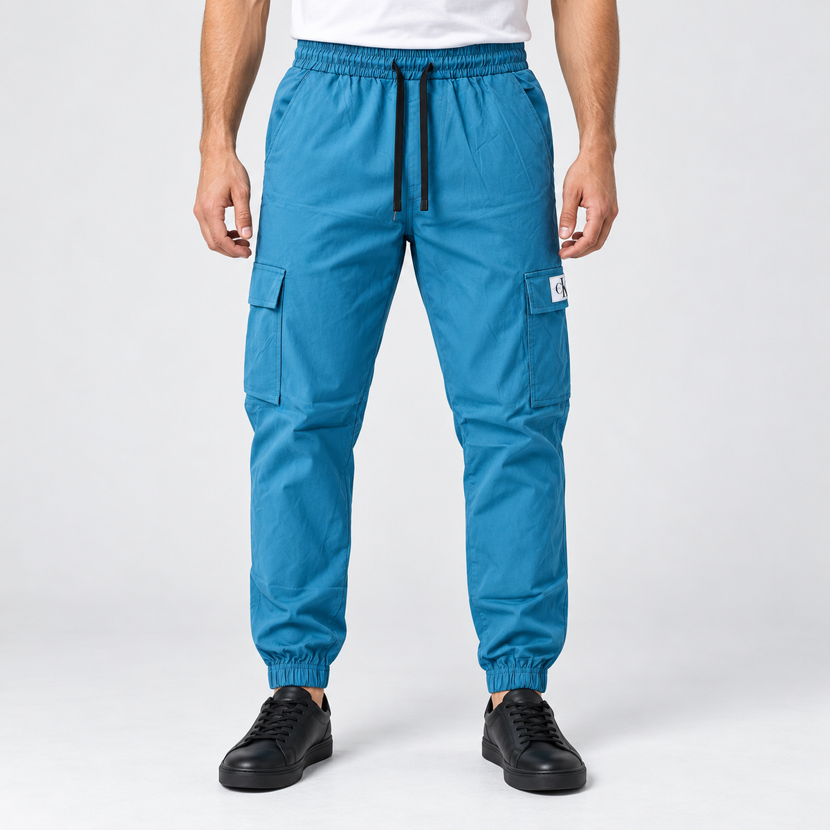 Teal blue cargo jogger pants on an adult male model, full front view.