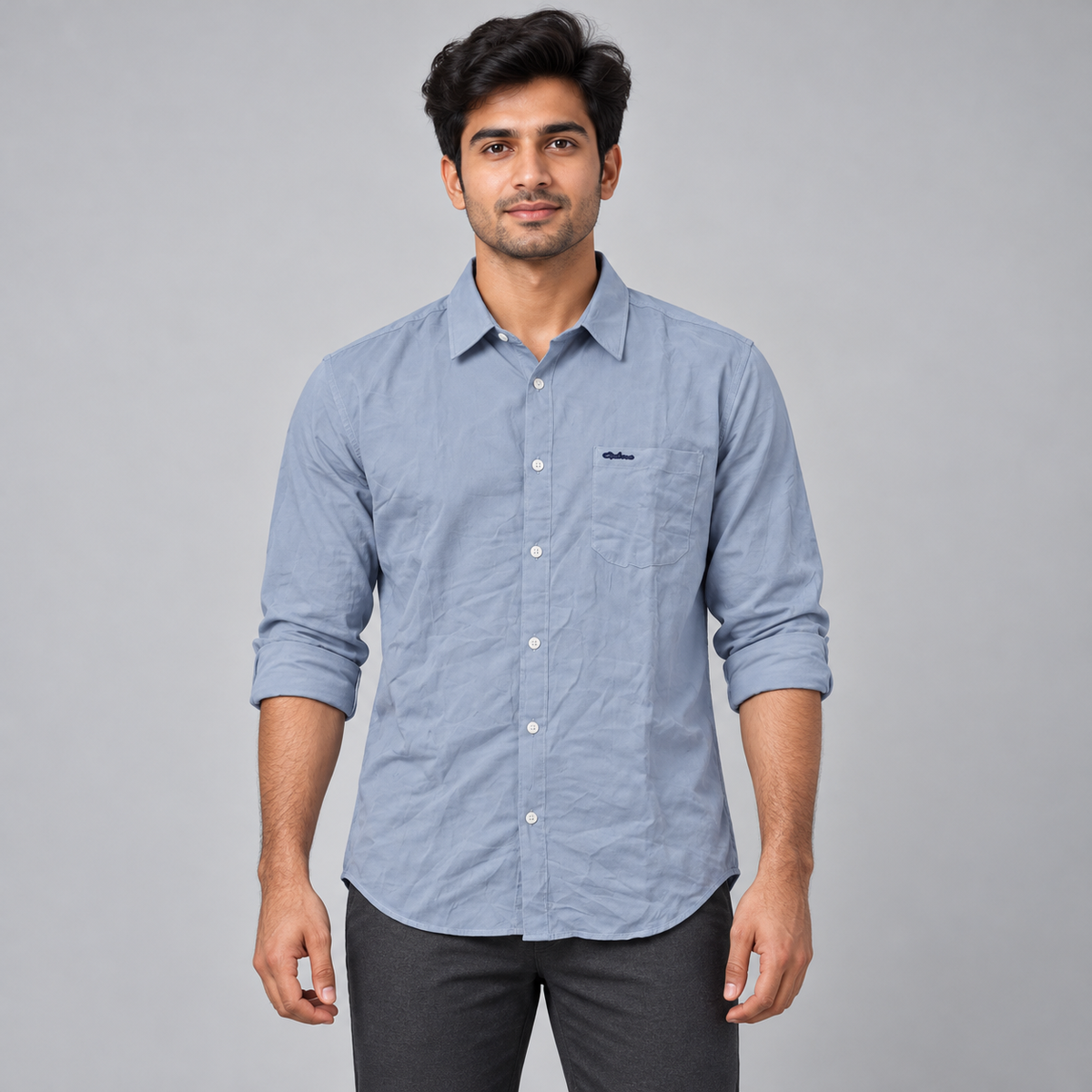 Light blue full sleeve shirt with small dark script pocket detail, on an adult model, front view